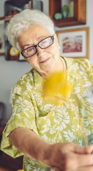 Eine ältere Frau pflegt ihre Blumen