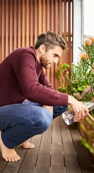 Ein Mann gießt die Blumen